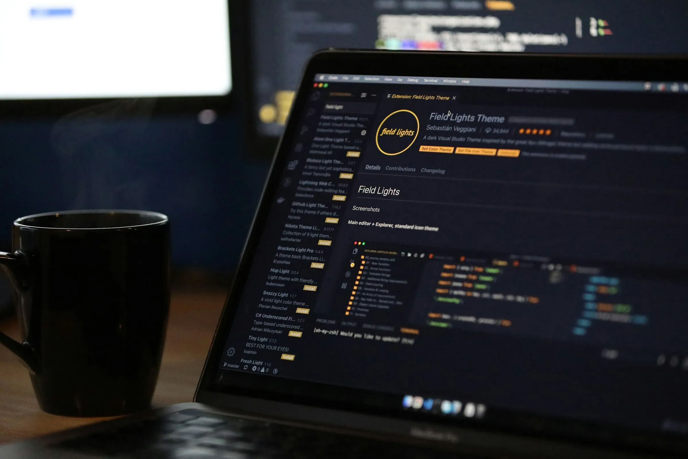 Laptop con código y una taza de café humeante